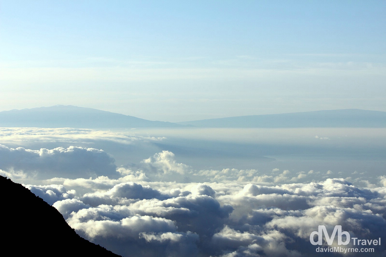 For me the sunrise from Haleakala was secondary to the amazing views, not only of the clouds hovering above Maui (& far below me) but also of the distant peaks of Mauna Kea (one the left) & Mauna Loa (on the right) on the Big Island, 100m/160km & 80m/128km &amp away respectively - it was especially gratifying peering across at Mauna Kea, having stood on its snowy, 13,796ft/4,205m summit a few days earlier. Haleakala National Park, Maui, Hawaii. March 6th 2013. 