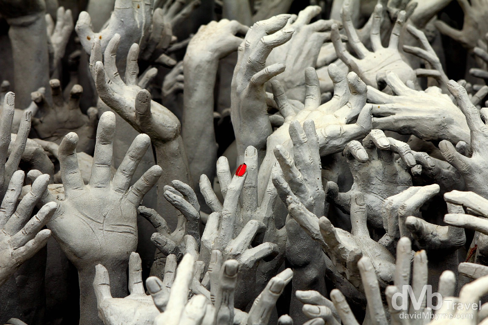 A lone red fingernail stands out in a sea of grey on a sculpture in the grounds of Wat Rong Khun, Chiang Rai, northern Thailand. March 11th 2012.