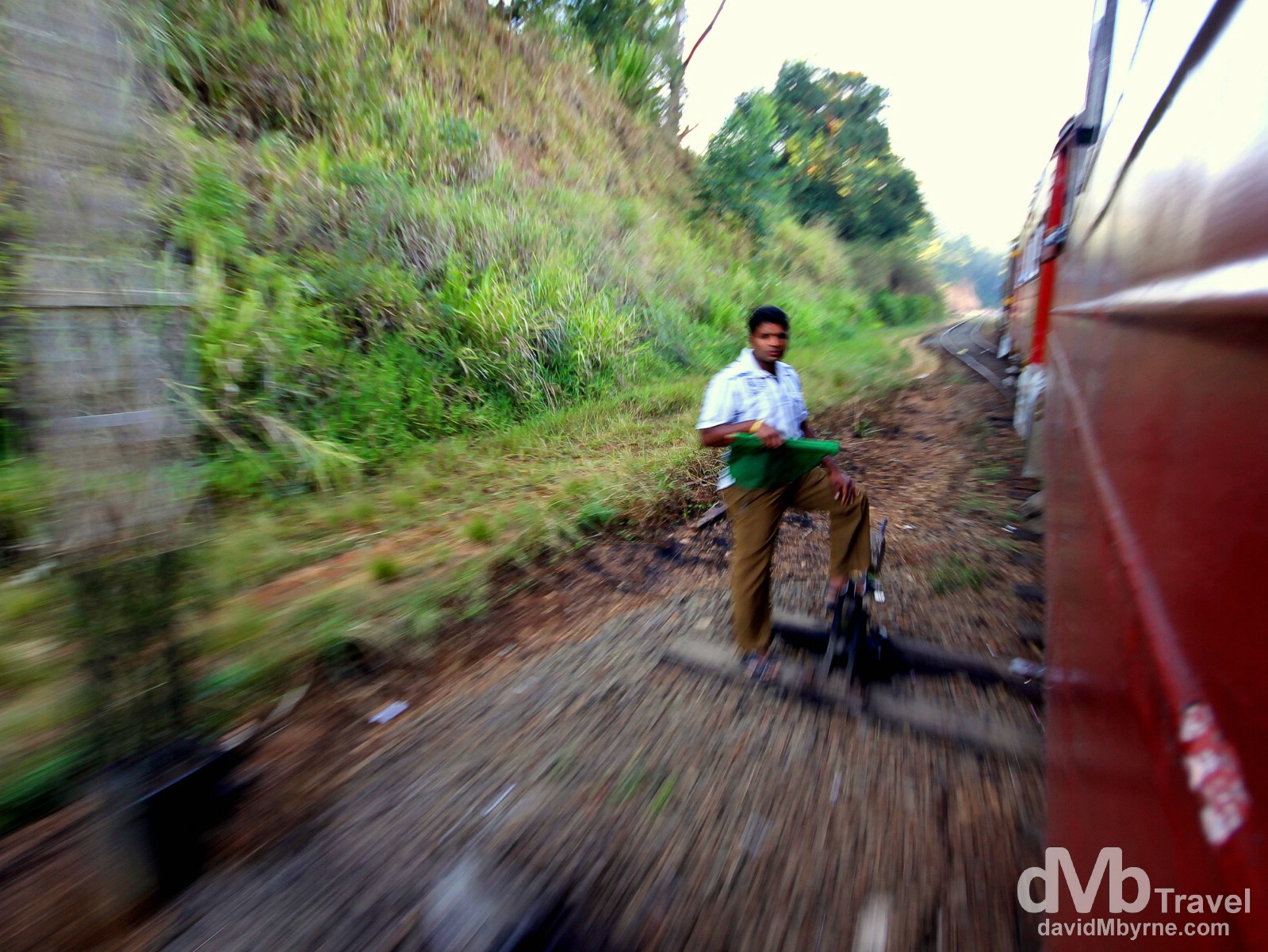 Speeding past a signal operator on the Badulla to Colombo train in central Sri Lanka. September 5th 2012.