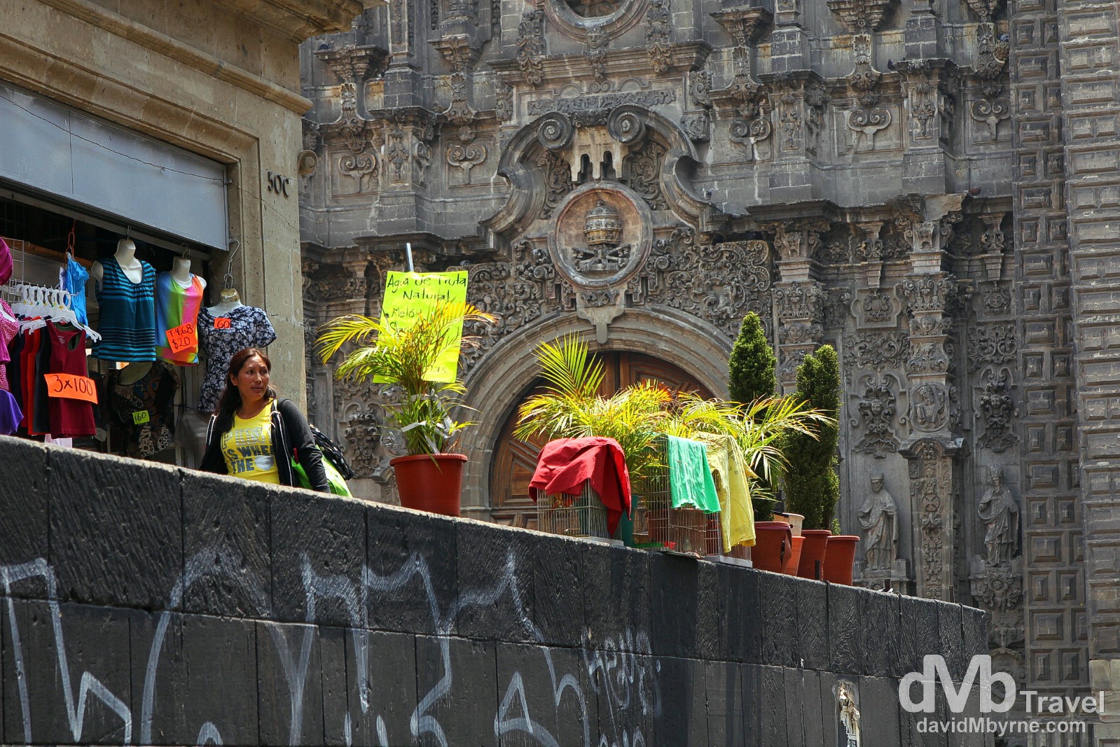 The hyper-baroque façade of Templo de la Santisima Trinidad, graffiti & clothes for sale as seen from Mondea, Central Mexico City. April 26th 2013.