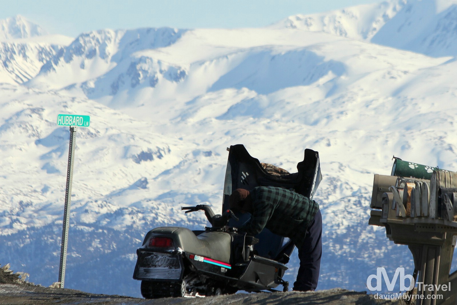 Tending to a snowmobile near Hubbard Lane on Skyline Drive, Homer, Kenai Peninsula, Alaska, USA. March 17th 2013. 