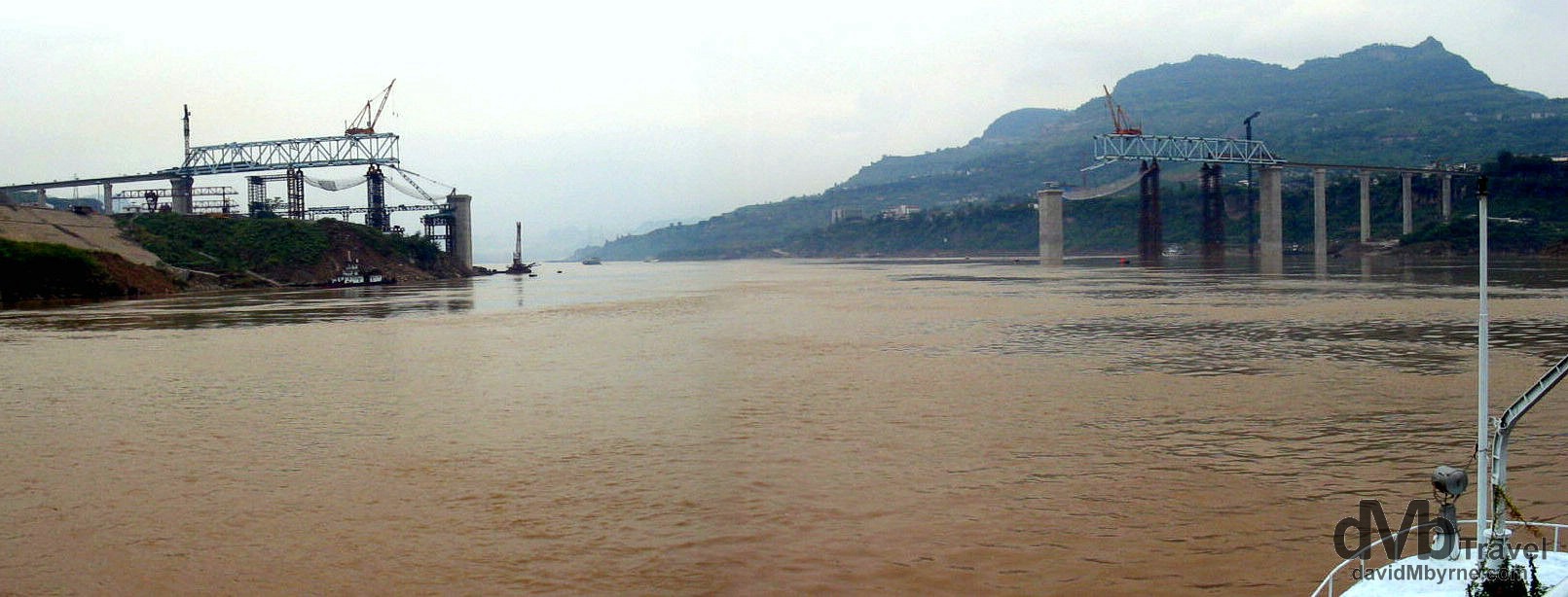 The construction of a bridge spanning the Yangtze River as seen from the river near Wan Xian, central China. September 26th, 2004.