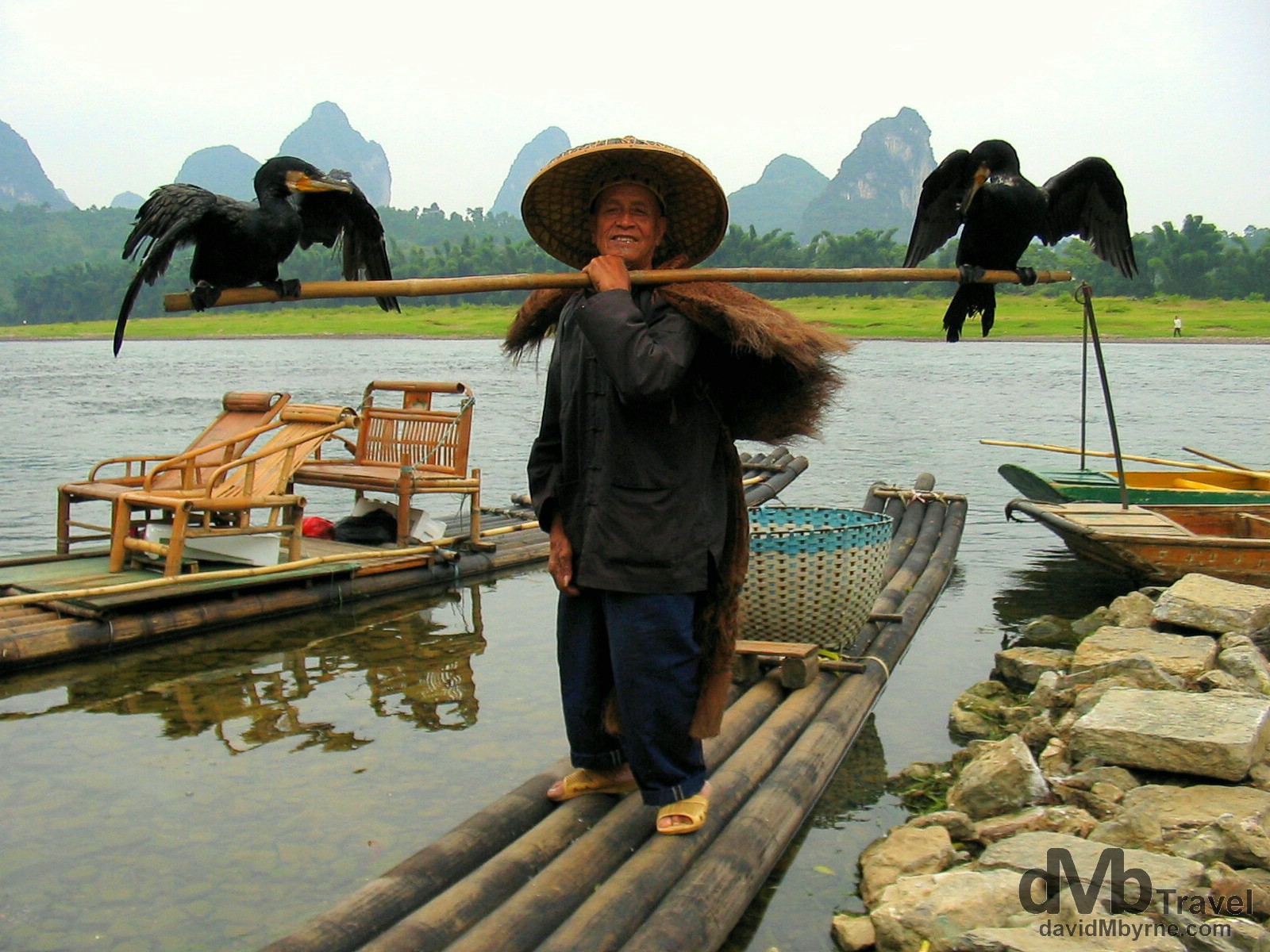 A Cormorant fisherman poses for a picture by the banks of the Li river in Yangshuo, Guangxi Province, Southern China. September 10th, 2004.