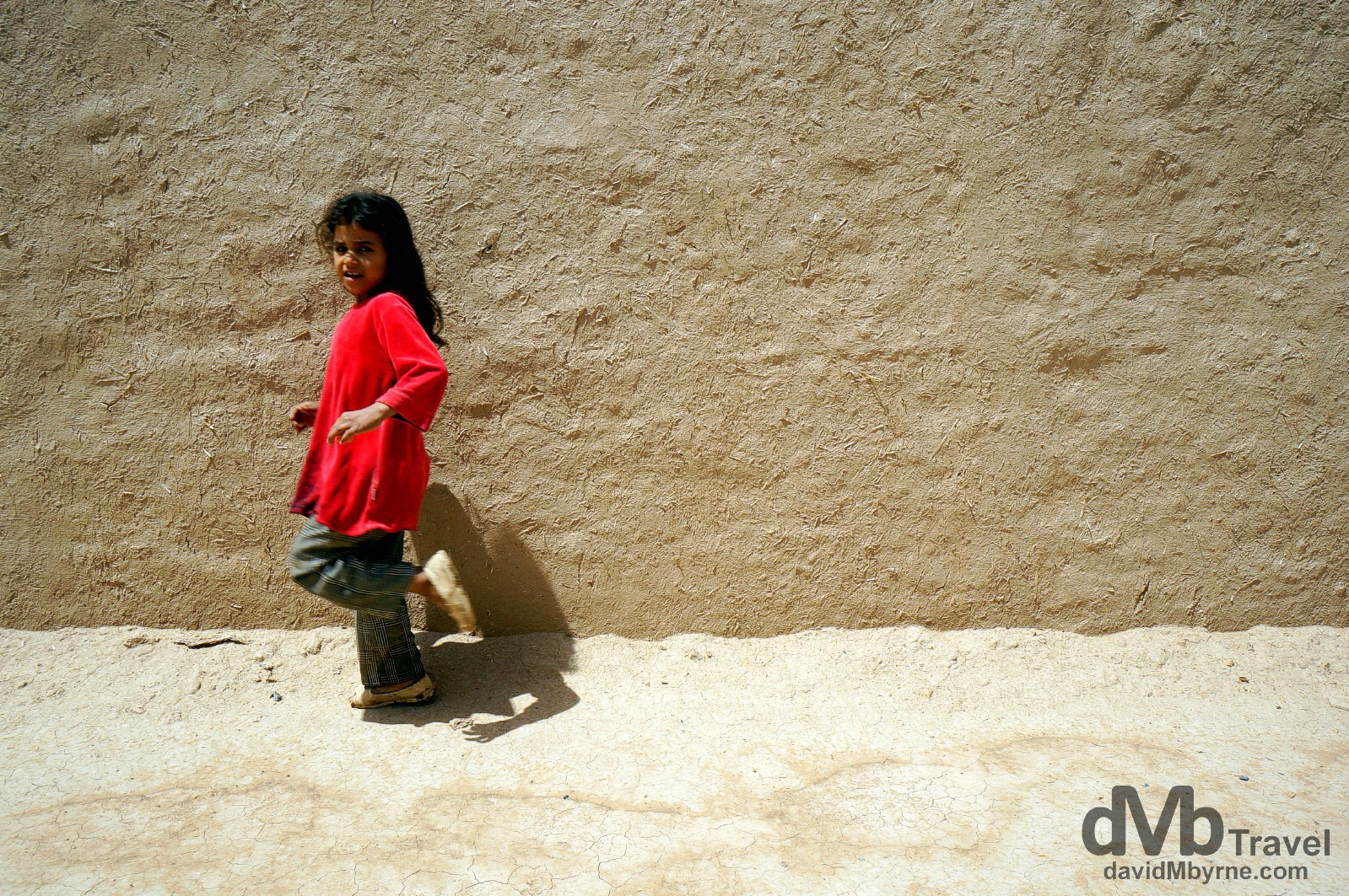 Walking by the pise (mud & rubble building material) walls of Ksar Oualad Abdelhalim, Rissani, Morocco. May 22nd, 2014.