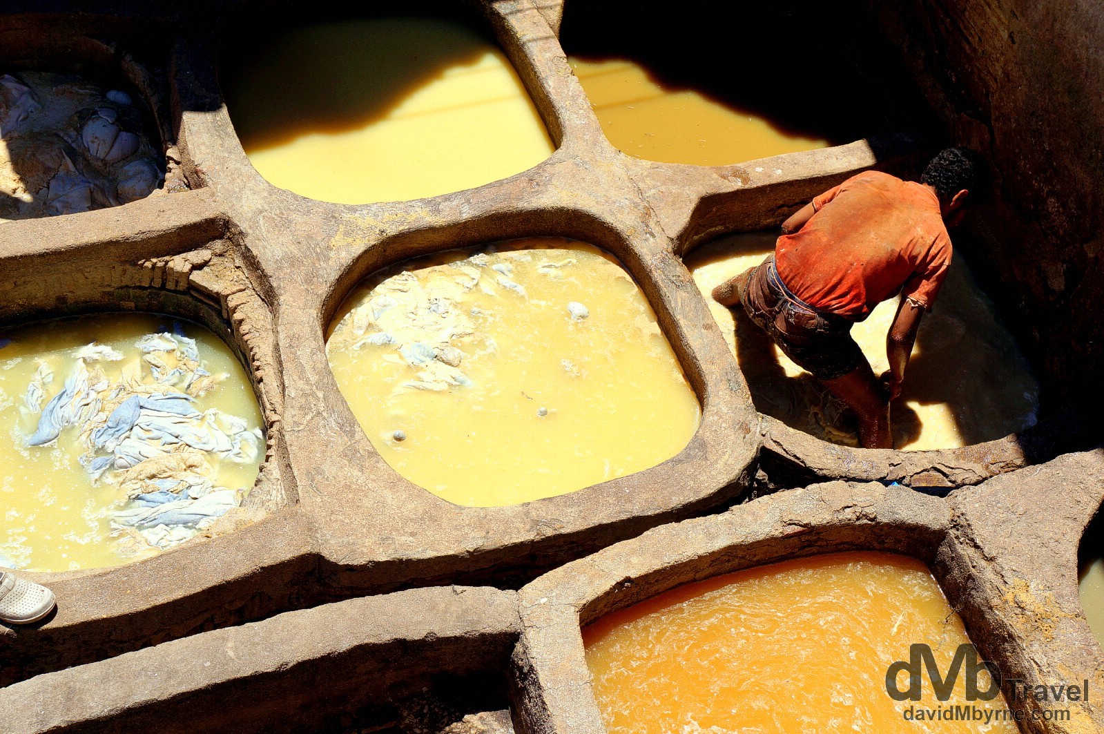 A worker in one of the pits of the Tanneries Chouwara, Fes el Bali, Fes, Morocco. May 29th, 2014. 