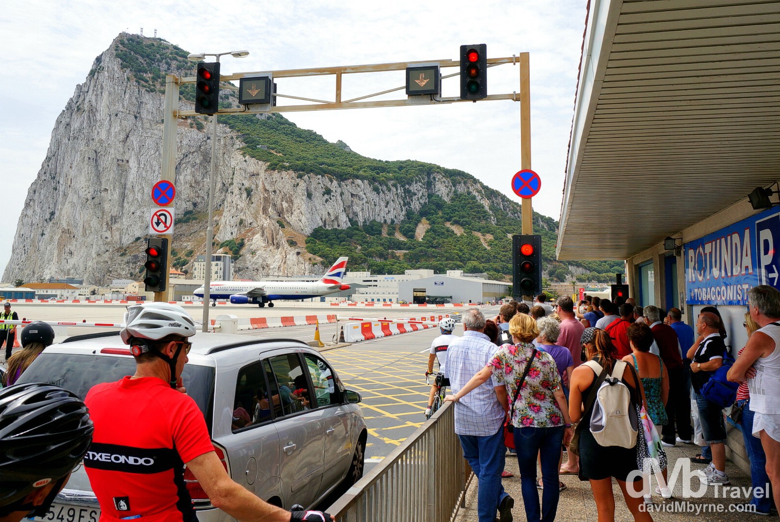 Pedestrians waiting for an arriving BA plane to taxi to its gate to enable passage across the runway of the International Airport in Gibraltar. June 5th, 2014.