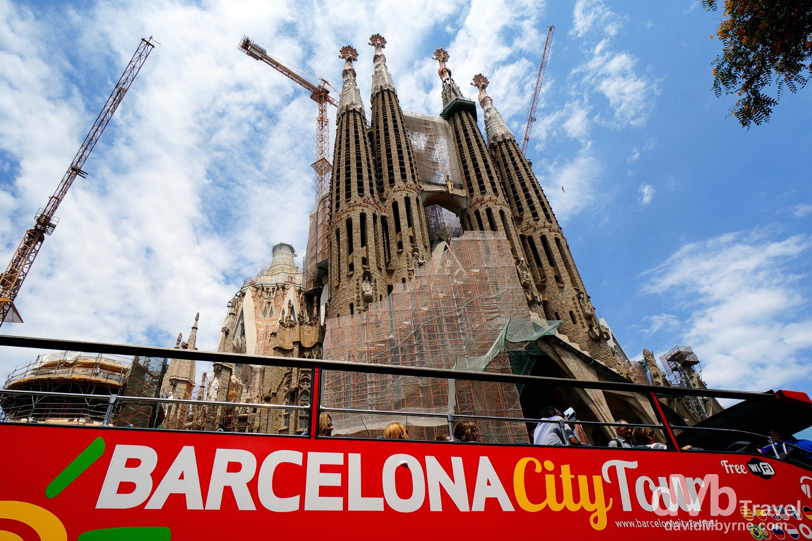 A City Tour bus passing the Passion Facade of the Sagrada Família in Barcelona, Catalonia, Spain. June 17th, 2014.