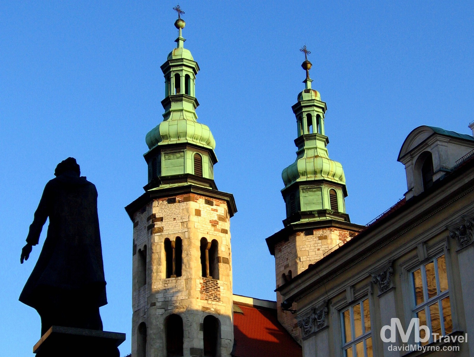 The silhouette of a statue & twin spires of Saint Andrew's Church in Old Town, Krakow, Poland. March 6, 2006.