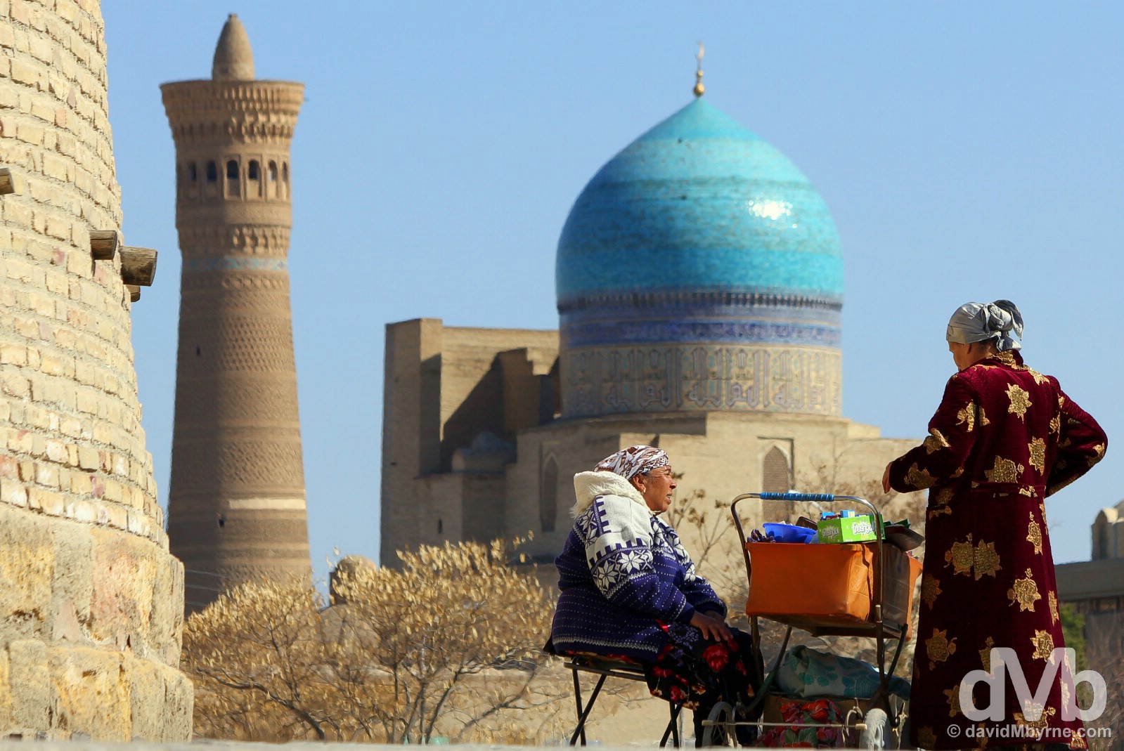 Conducting business by the walls of the Ark in the Registan in view the Kalon Mosque & Minaret. Bukhara, Uzbekistan. March 12, 2015. 