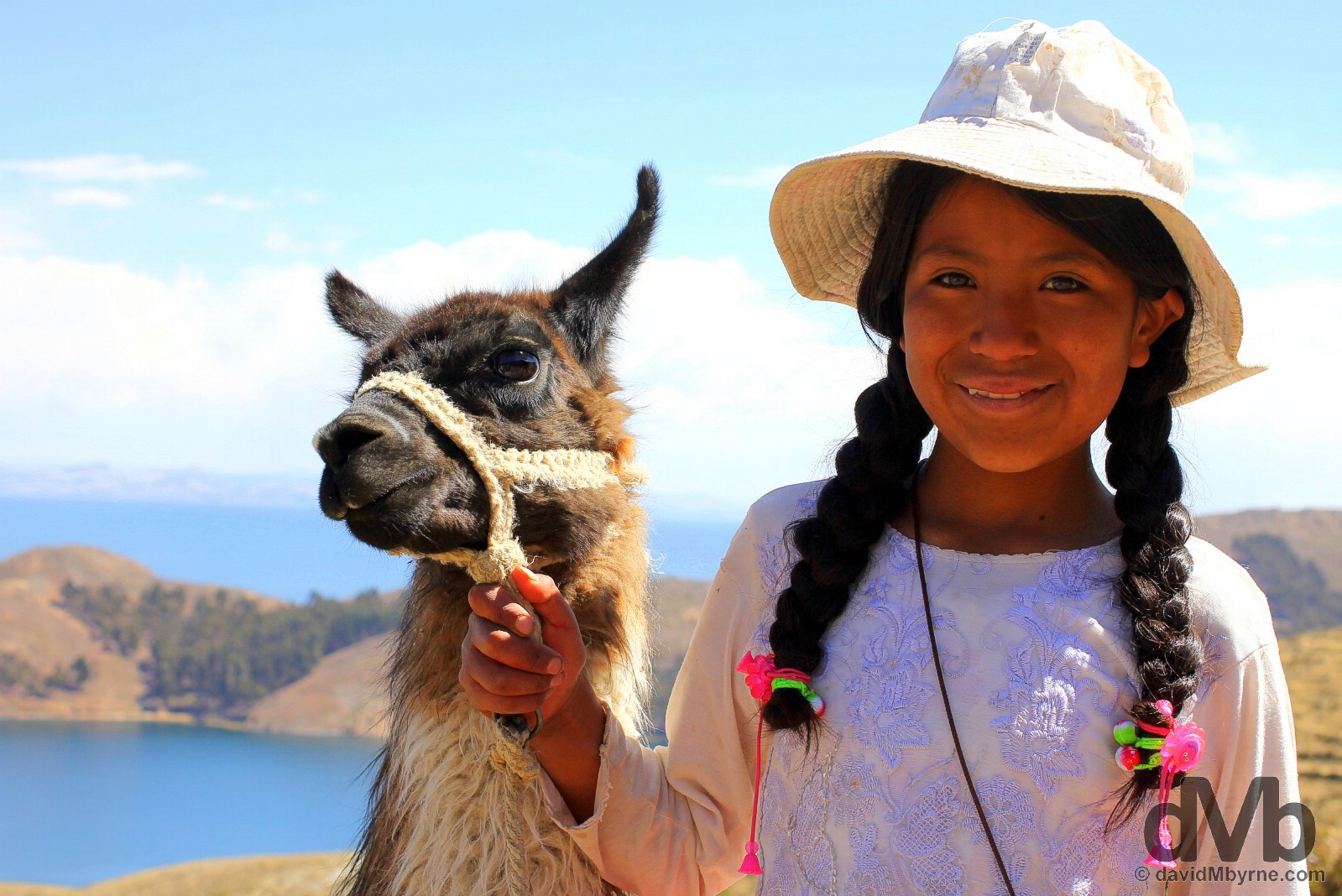 A girl with a llama on the path approaching the village of Yumani on Isla del Sol in Lake Titicaca, Bolivia. August 24, 2015. 