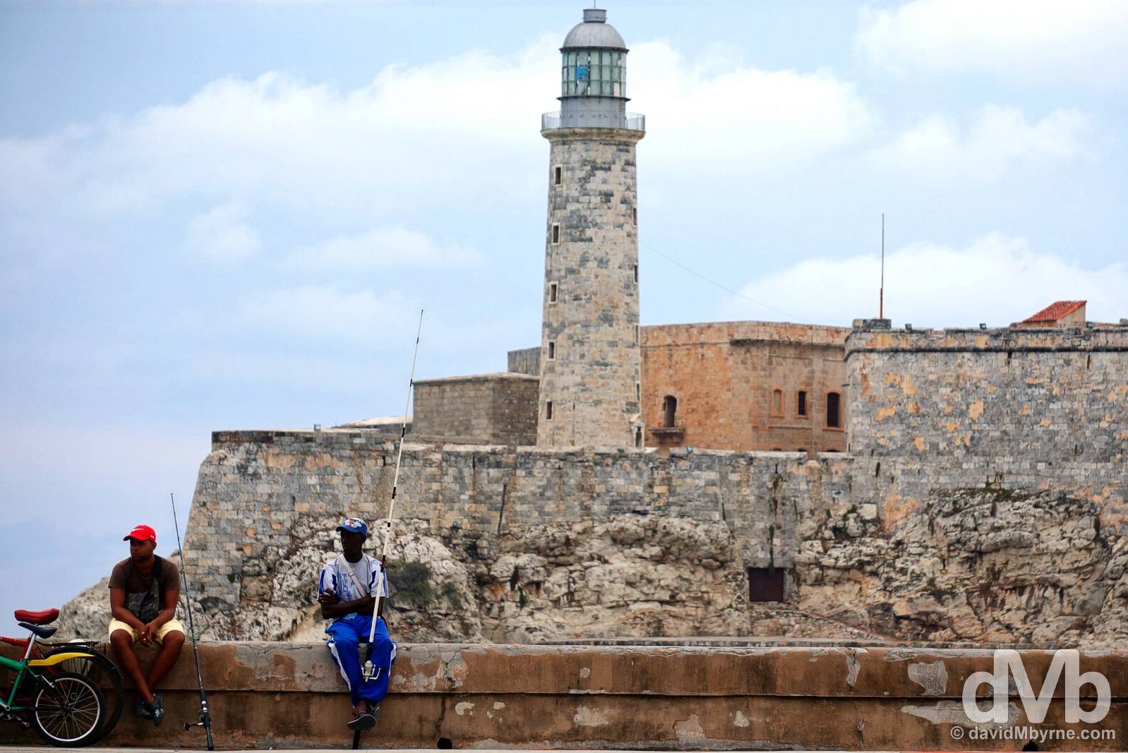 Sitting on the walls of the Malecon fronting Castillo de San Salvador de la Punta in Havana, Cuba. April 30, 2015.