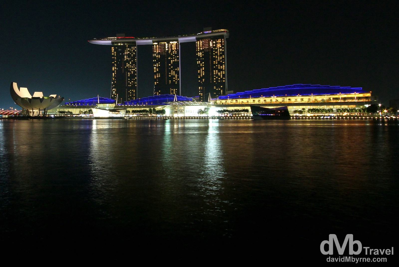The lotus-shaped Arts & Science Museum (left), the Marina Bay Sands Hotel (centre) & the Shoppes At Marina Bay Sands (right), as seen from the waterfront of Marina Bay in the Singapore Central Business District (CBD). The hotel, one of the newest features of the ever-changing Singapore skyline, features three 55-storey hotel towers which are connected by a 340 metre, 1 hectare sky terrace on the roof, named Sands SkyPark. The SkyPark, perched 191 metres above the ground, has the capacity to hold 3,900 people. It's only the world's largest public cantilevered platform & is home to a 134-meter (478 ft) infinity pool, the world's longest elevated swimming pool, rooftop restaurants, gardens, palm trees & an observation deck. The Marina Bay Sands itself is a lot of things - a hotel, a casino, an upscale shopping arcade (Shoppes At Marina Bay Sands), a convention centre etc. - but at its core it's somewhere to spend an awful lot of money. Originally set to open in 2009, delays & budget overruns (it was budgeted at SGD$3 billion (€1.8b) but actually ended up costing SGD$8 billion (€4.7), making it the world's most expensive standalone casino property) meant it didn't actually open until early-mid 2010, and only then in stages - it wasn't officially opened until February 2011 & the last portion of it to open was in September of that year. Singapore. March 28th 2102.