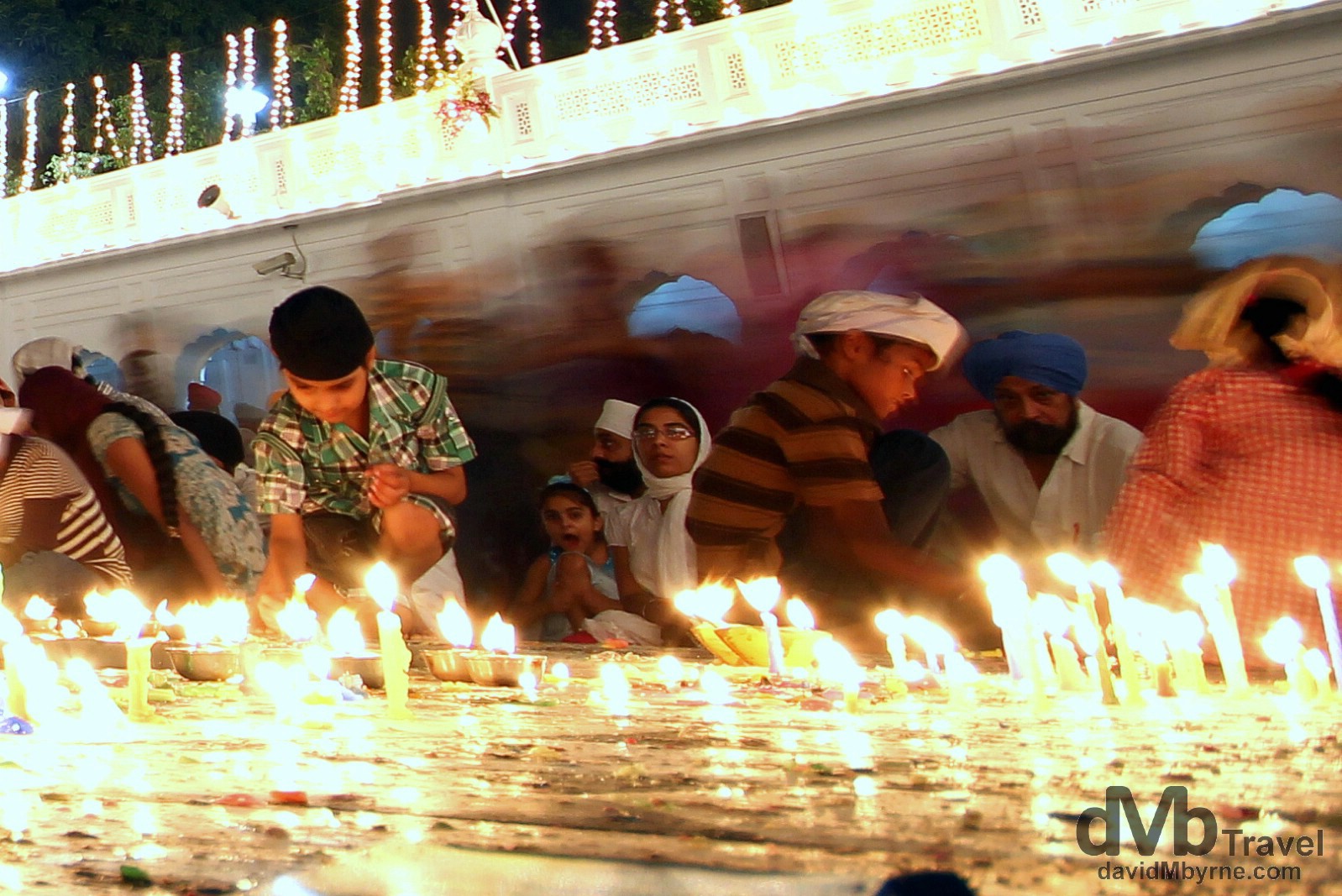 Lighting candles by the edge of the Amrit Sarovar (Pool of Nectar) in the Golden Temple complex, Amritsar, India. October 9th 2012.