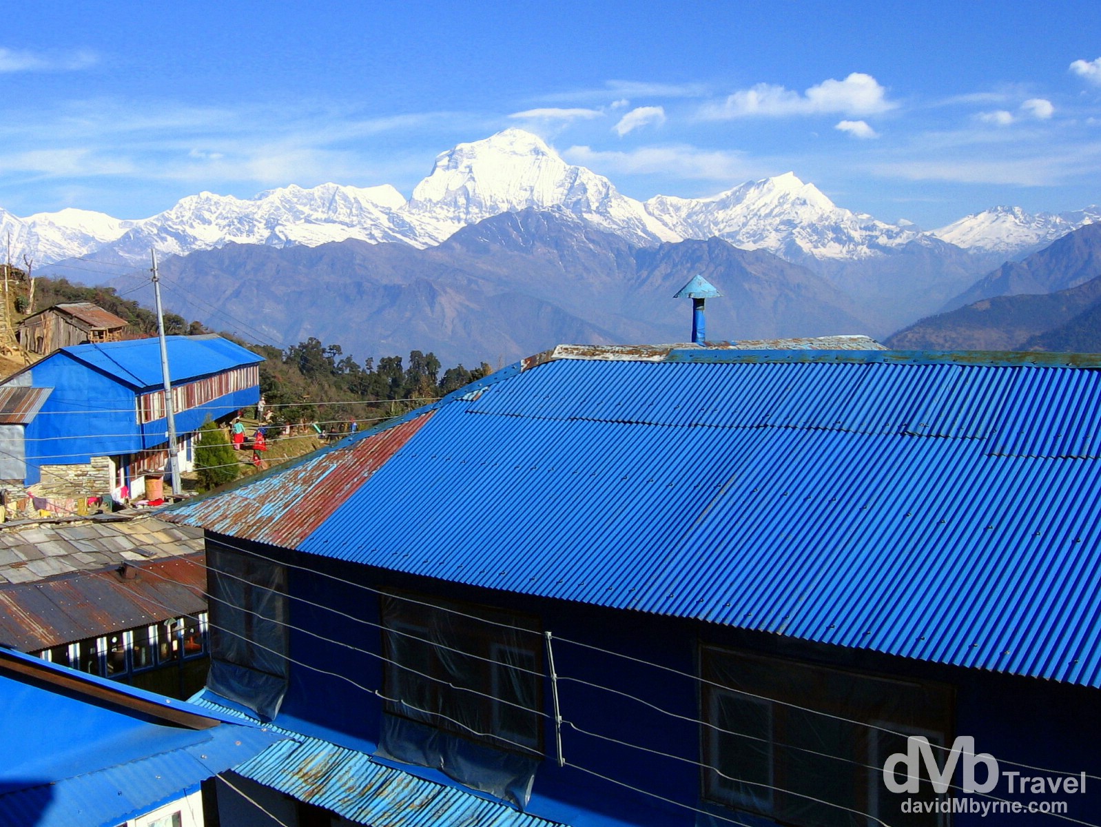 The distinctive blue galvanised roofs of the buildings of Ghorepani village, Nepal. The village sits 1,500ft, 450 metres below Poon Hill and the sight of Dhaulagiri (27,000ft, 8,167m) behind the village makes a spectacular backdrop. Ghorepani Village, Annapurna Conservation Area, Nepal. March 12th 2008.