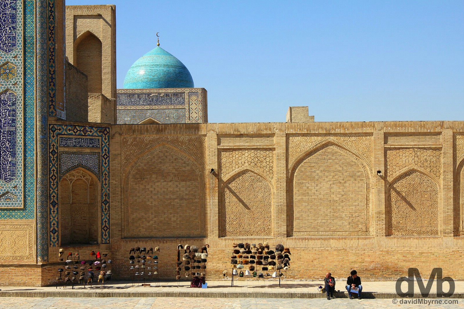 Sitting by the walls of the Kalon Mosque as seen from the Mir-i-Arab Medressa in Bukhara, Uzbekistan. March 12, 2015.