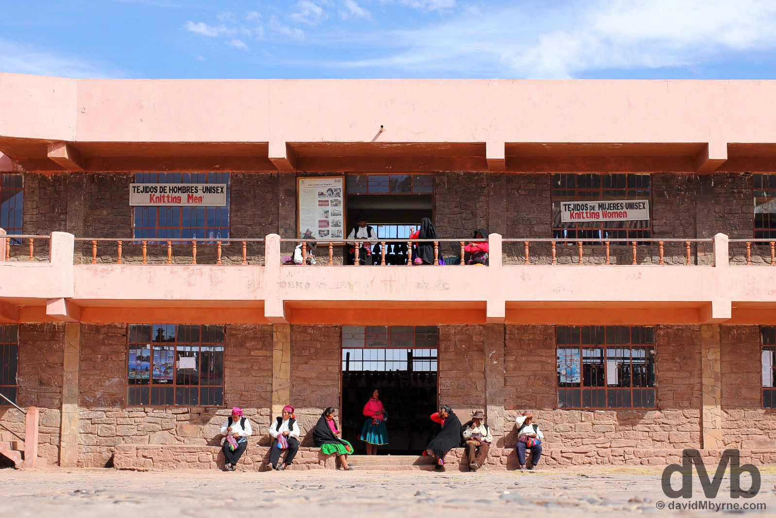 Locals sitting outside a weaving market in the main square of Taquile Island, Lake Titicaca, Peru. August 20, 2015. 