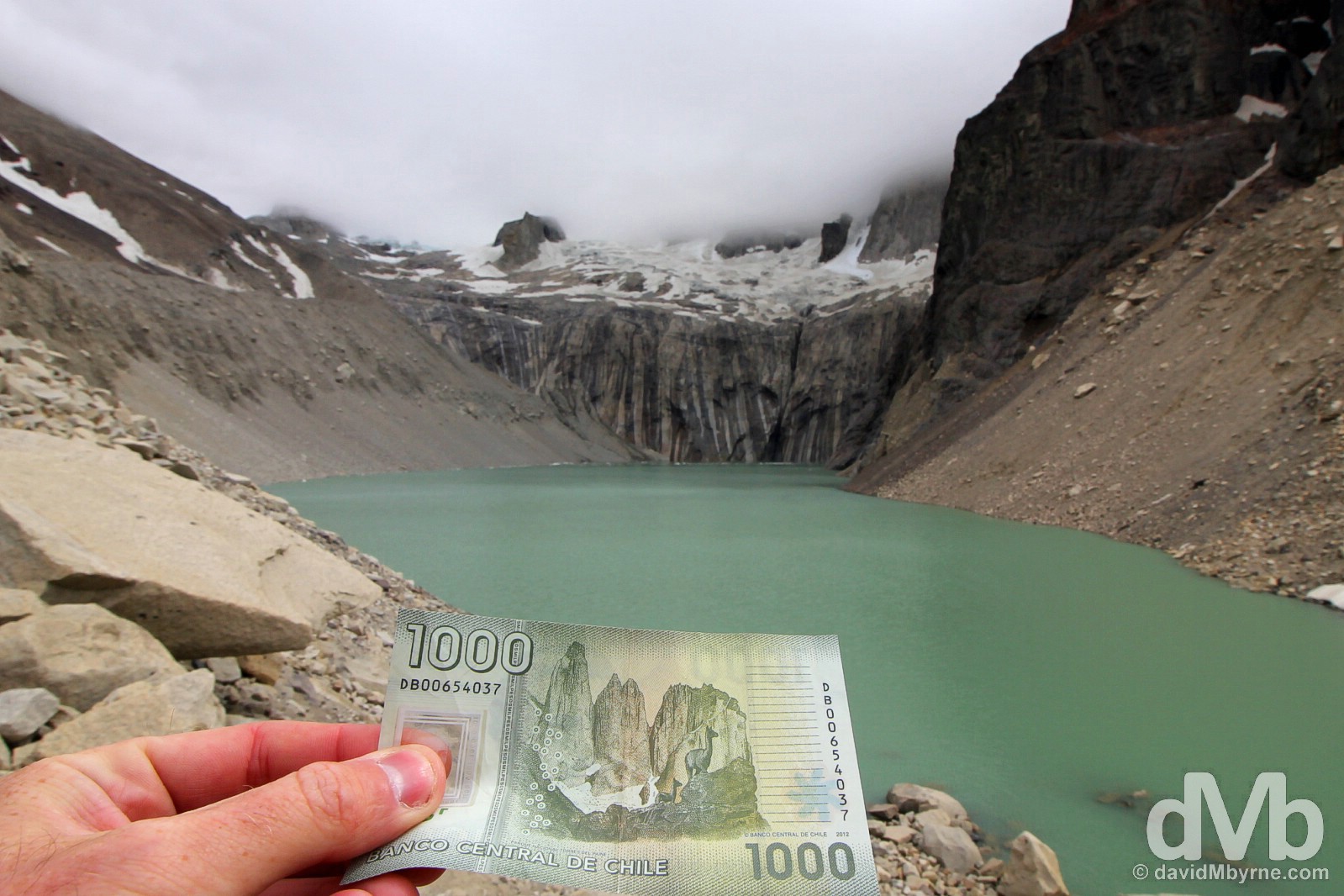 The missing pieces. The Torres del Paine peaks, shrouded by cloud on this day, as seen on the rear of the Chilean 1000 peso note on the edge of Laguna Torre in Parque Nacional Torres Del Paine, southern Patagonia, Chile. November 7, 2015. 
