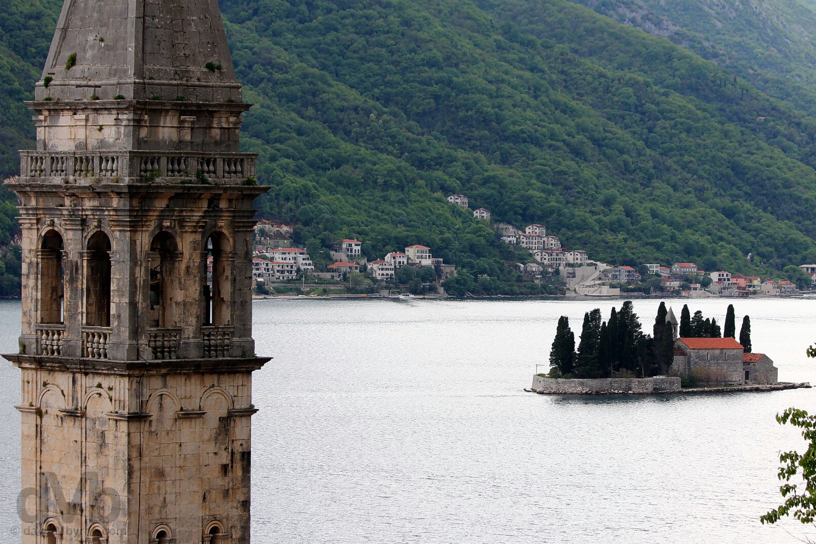 The spire of the 17th century St. Nicholas Church and the natural Sveti Dorde (Island of St. George, home to the 12th-century Saint George Benedictine monastery) off the coast of Perast, Bay of Kotor, Montenegro. April 19, 2017.